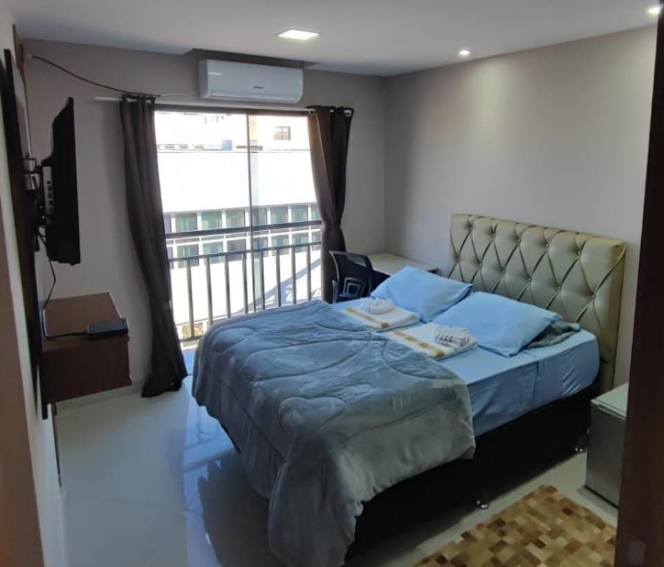 Quarto de casal com porta de vidro para a sacada